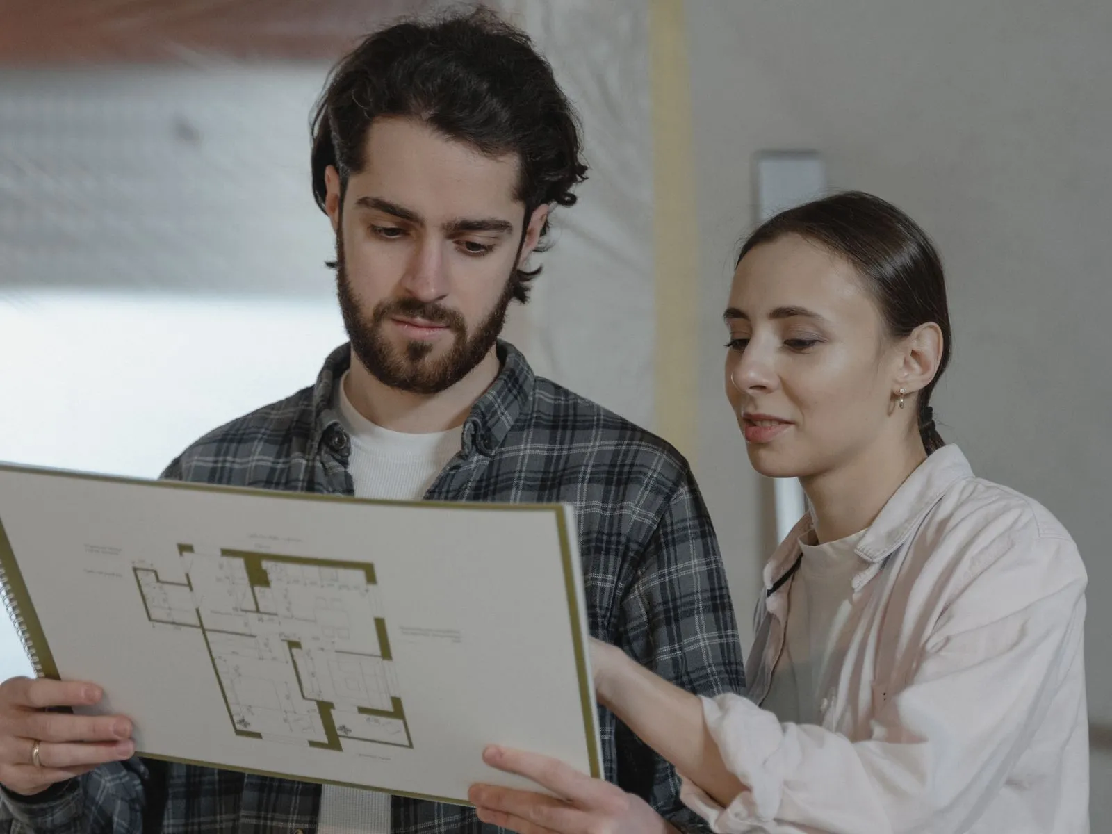 Homeowners reviewing renovation floor plans for their permit