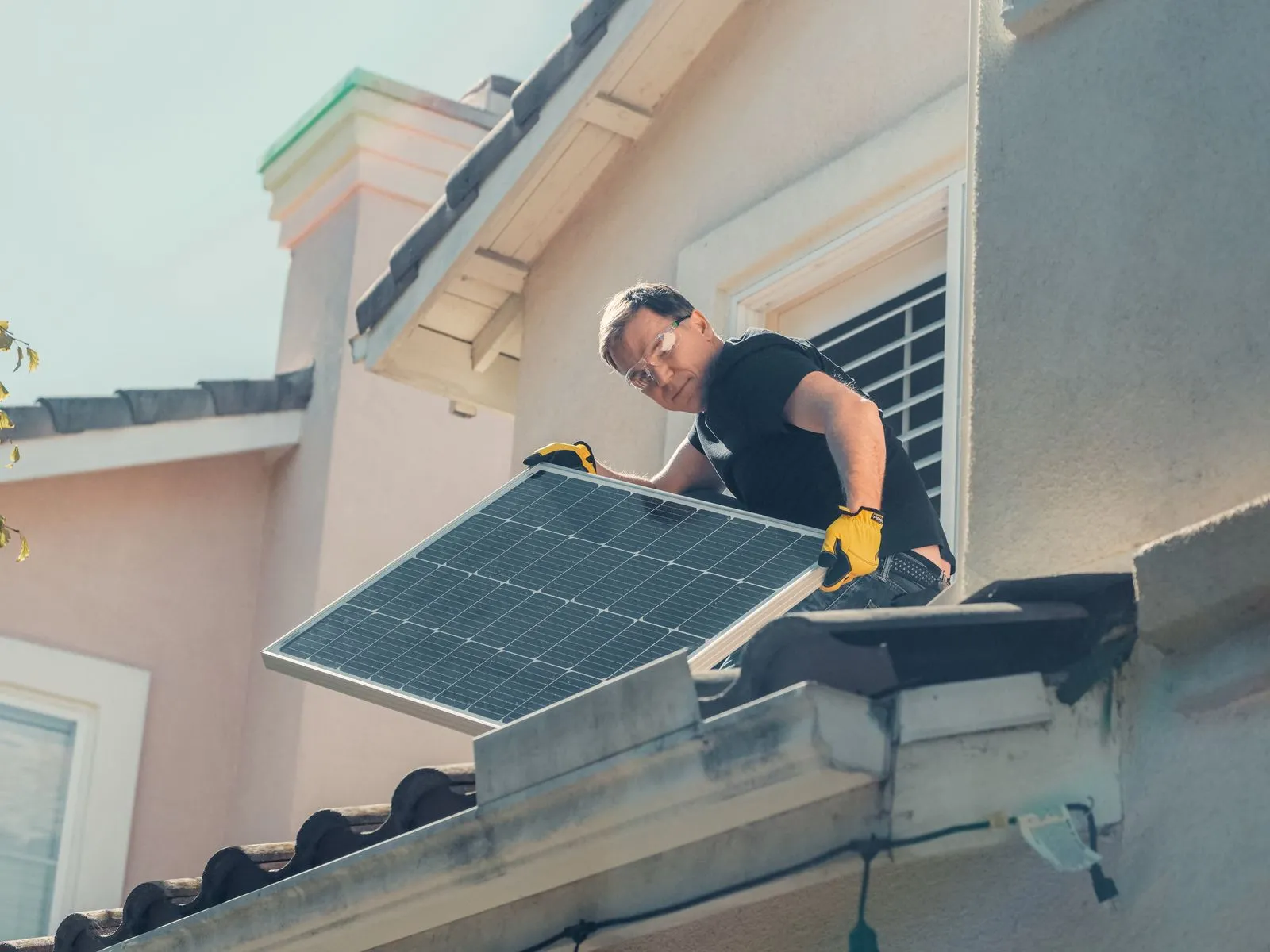 Solar installer fitting panels on a residential roof